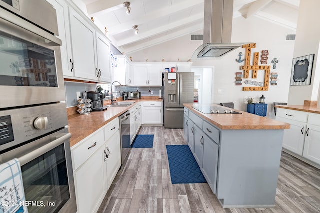 kitchen featuring stainless steel appliances, sink, white cabinets, and lofted ceiling with beams