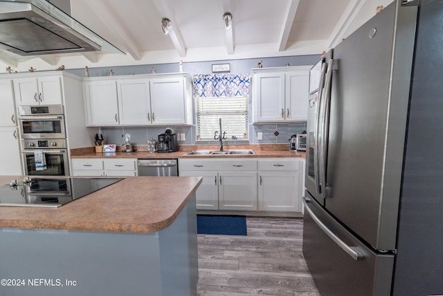 kitchen with beam ceiling, sink, white cabinets, and stainless steel appliances