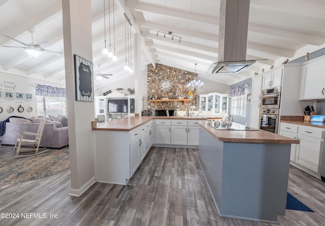 kitchen with white cabinetry, dark wood-type flooring, lofted ceiling with beams, black electric cooktop, and island range hood