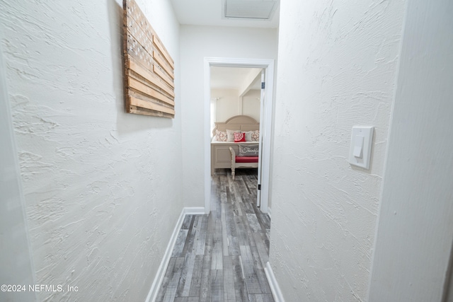 corridor with hardwood / wood-style flooring