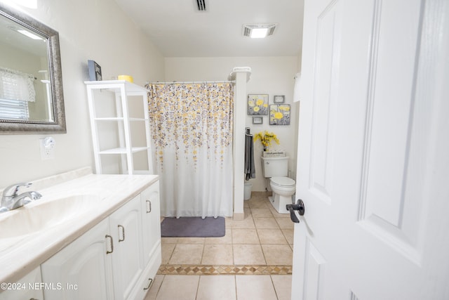 bathroom with tile patterned flooring, vanity, toilet, and walk in shower