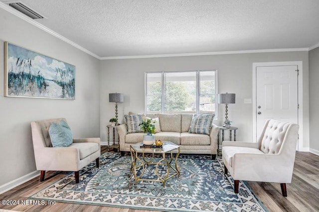 living room with wood-type flooring, a textured ceiling, and ornamental molding