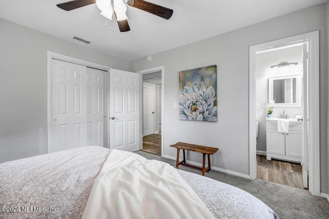 carpeted bedroom featuring connected bathroom, ceiling fan, a closet, and sink