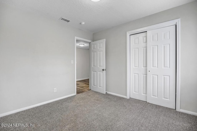 unfurnished bedroom with carpet flooring, a closet, and a textured ceiling