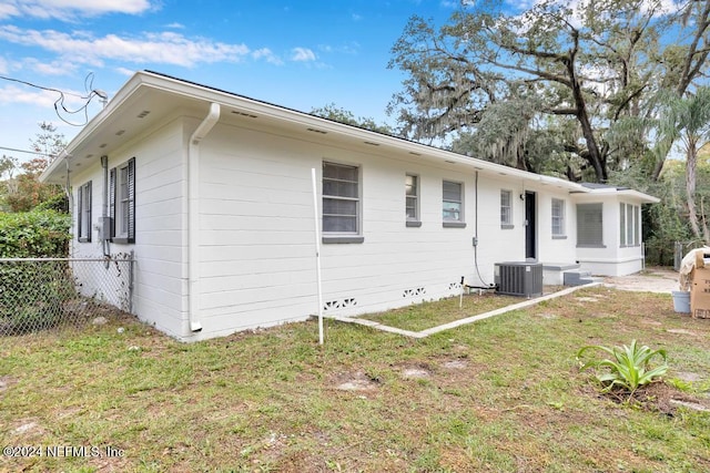 exterior space with a lawn and central AC unit