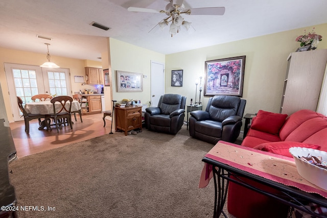 carpeted living room with ceiling fan