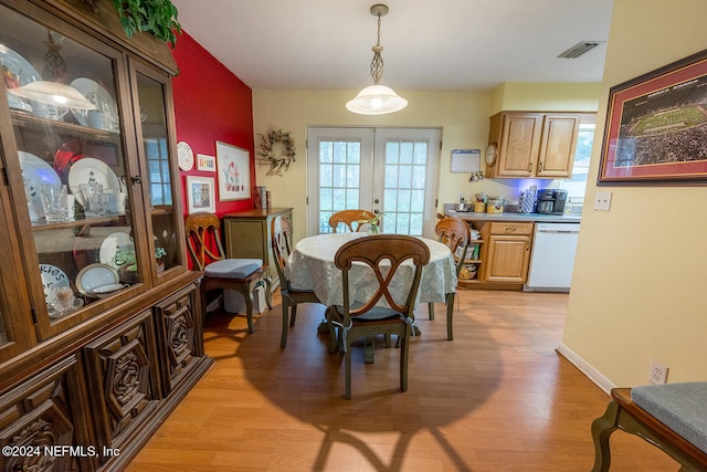 dining space with light hardwood / wood-style floors and french doors