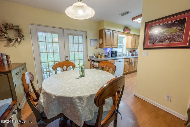 dining area with french doors, light hardwood / wood-style floors, and sink