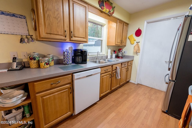 kitchen featuring stainless steel fridge, light wood-type flooring, white dishwasher, and sink