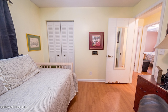 bedroom with light wood-type flooring and a closet