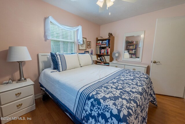 bedroom with dark hardwood / wood-style floors and ceiling fan