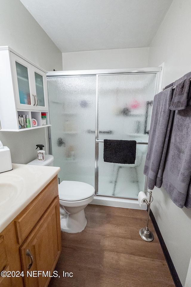 bathroom featuring vanity, toilet, wood-type flooring, and walk in shower