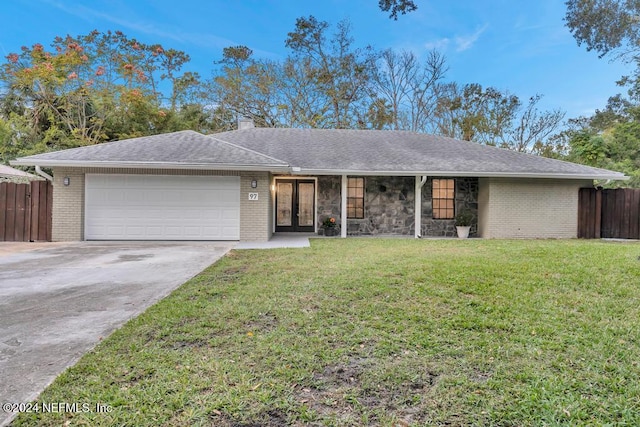 ranch-style house featuring a garage and a front lawn