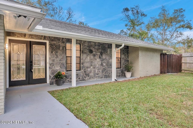 property entrance with a yard and french doors