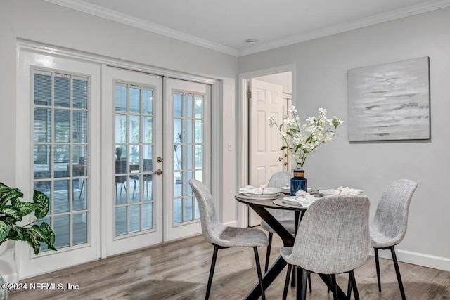 dining room featuring wood-type flooring, crown molding, and french doors