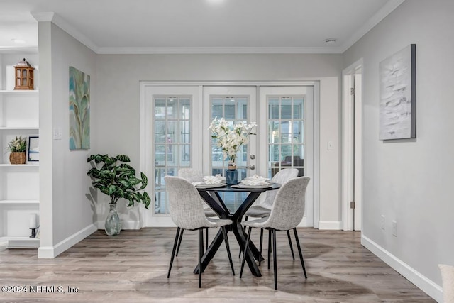 dining area with wood-type flooring, plenty of natural light, and ornamental molding