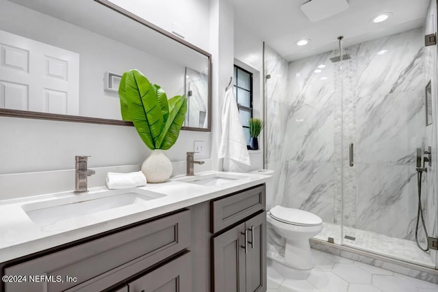 bathroom featuring tile patterned flooring, vanity, toilet, and a shower with shower door