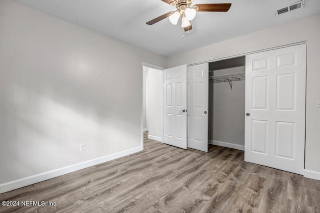 unfurnished bedroom featuring ceiling fan, a closet, and light wood-type flooring