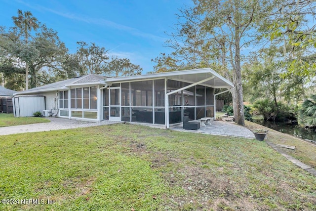 back of property featuring a sunroom and a yard