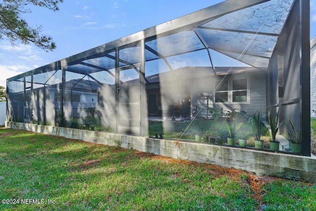 view of home's exterior featuring a lanai and a lawn