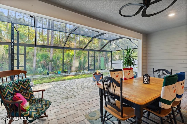 view of patio featuring ceiling fan and a lanai