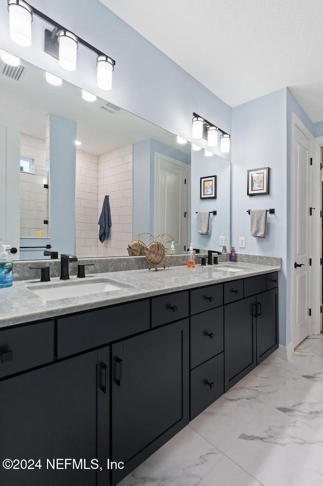 bathroom featuring a tile shower and vanity