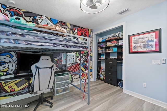 bedroom featuring a textured ceiling and light wood-type flooring