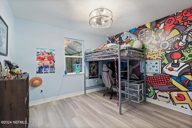 bedroom featuring a textured ceiling and light hardwood / wood-style floors