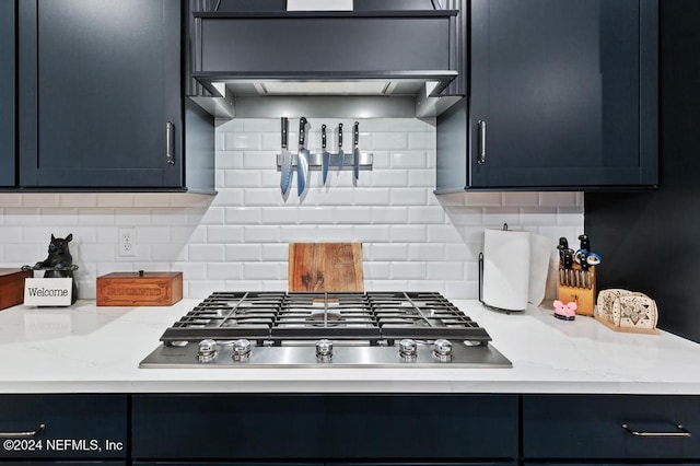 kitchen with light stone counters, backsplash, and stainless steel gas cooktop