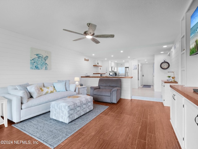 living room featuring ceiling fan and light hardwood / wood-style flooring