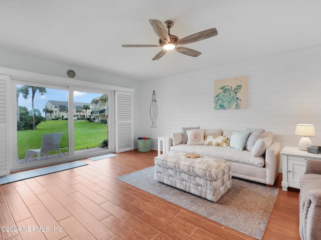 living room featuring ceiling fan and light hardwood / wood-style floors