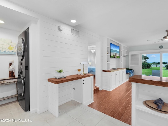 kitchen featuring butcher block countertops, ceiling fan, light tile patterned floors, and white cabinets