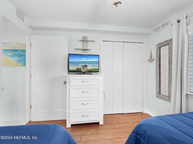 bedroom with a textured ceiling and a closet