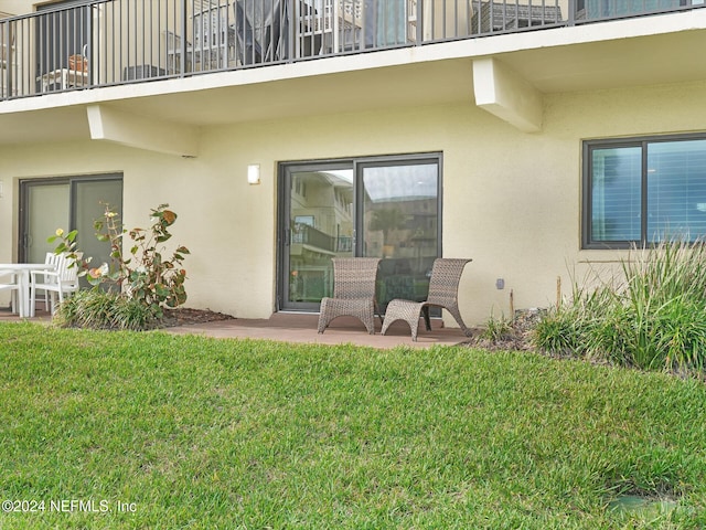 property entrance with a lawn and a patio area