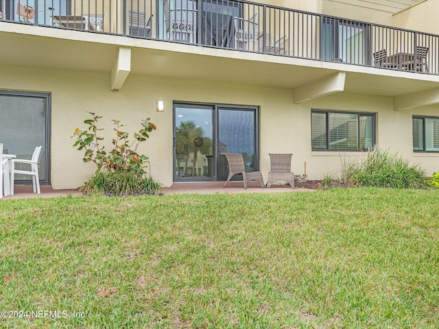 8550 A1A S Unit 13131, Saint Augustine, FL 32080 - doorway to property with a balcony, stucco siding, a patio area, and a lawn