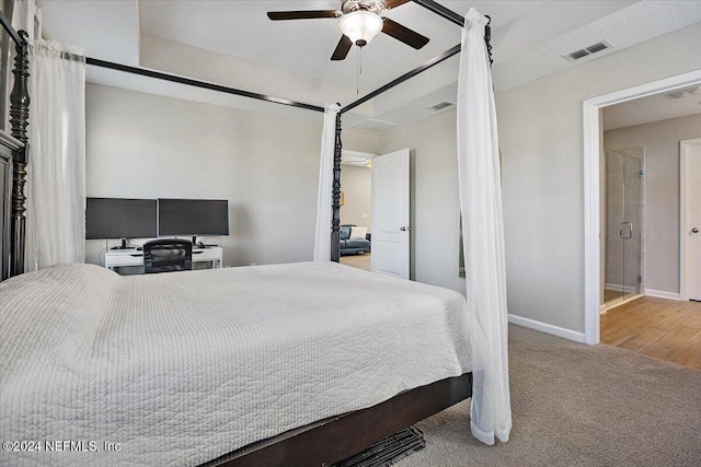 bedroom featuring connected bathroom, hardwood / wood-style flooring, and ceiling fan