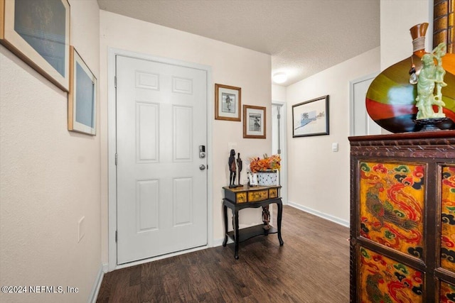 foyer featuring dark hardwood / wood-style floors and a textured ceiling