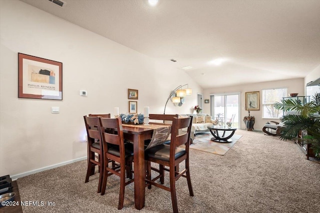 dining space featuring carpet flooring and vaulted ceiling