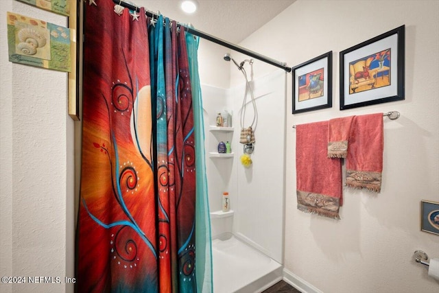 bathroom featuring a textured ceiling and walk in shower