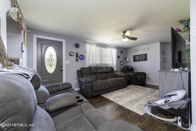 living room featuring a textured ceiling, ceiling fan, and dark wood-type flooring