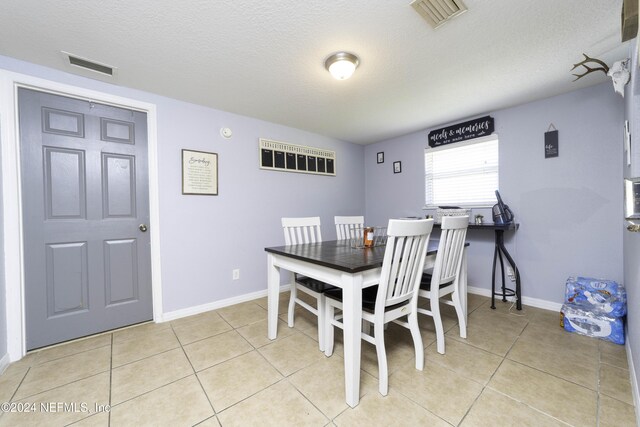 dining room with light tile patterned floors and a textured ceiling