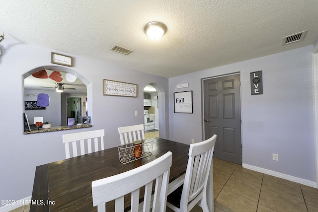 tiled dining area featuring ceiling fan and a textured ceiling