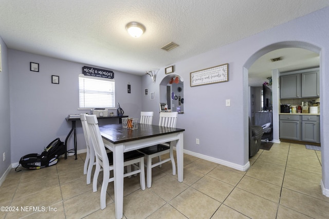 tiled dining room with a textured ceiling