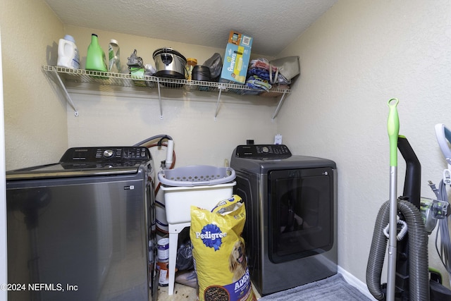 washroom with washing machine and dryer and a textured ceiling