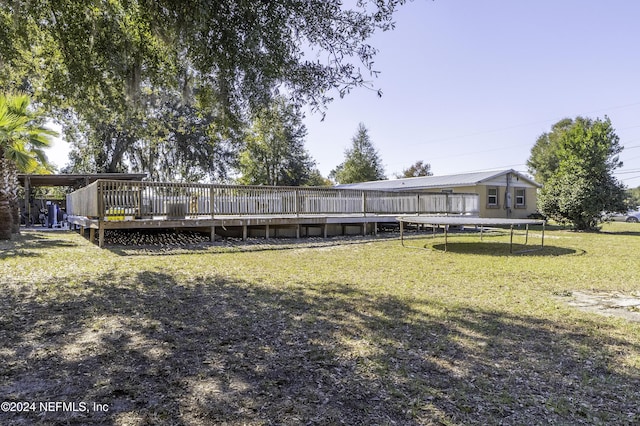 view of yard with a deck and a trampoline