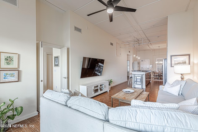 living room featuring ceiling fan and a high ceiling