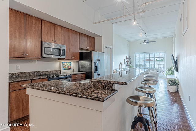 kitchen featuring a breakfast bar, stainless steel appliances, a kitchen island with sink, and dark hardwood / wood-style floors