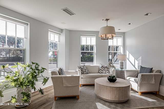 living room with wood-type flooring and an inviting chandelier