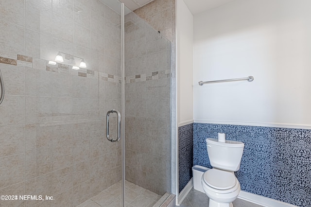 bathroom with an enclosed shower, toilet, and tile walls