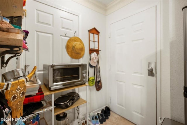 interior space with light tile patterned floors and crown molding